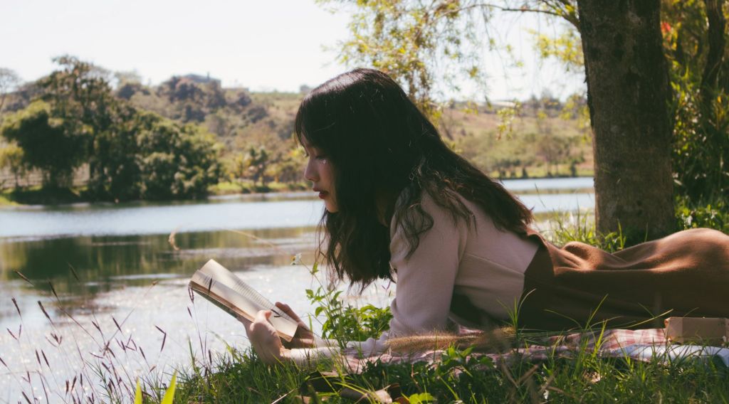 Woman reading by a lake. Photo by Nguyen Thu Hoai on Unsplash
